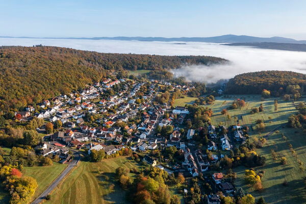 Luftaufnahme eines kleinen Dorfes im Taunus mit Morgennebel über dem Tal © istockphoto.com/Harald007